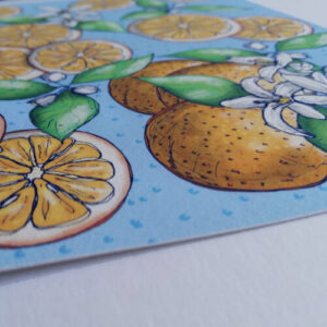 A close up of the edge of a Giclée art print. The Artwork is of hand drawn oranges.